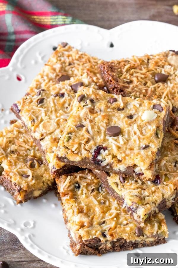 Christmas Magic Cookie Bar Recipe for Holiday Parties 4 A plate of Christmas magic cookie bars cut into squares and stacked.