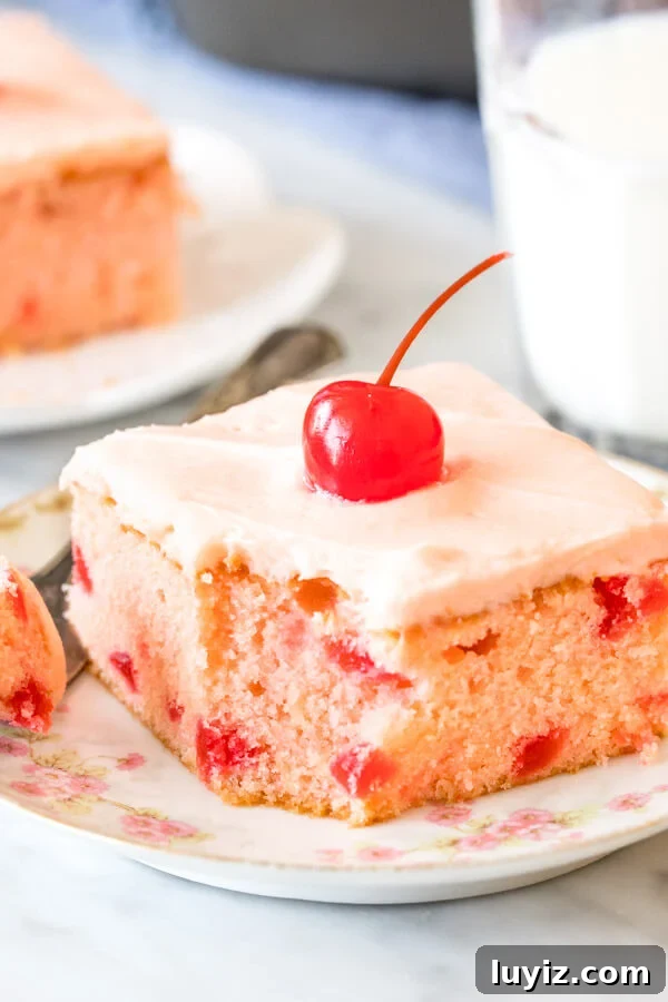 Moist Maraschino Cherry Cake Recipe with Cherry Glaze 4 A slice of cherry chip cake with a bite taken out of it.