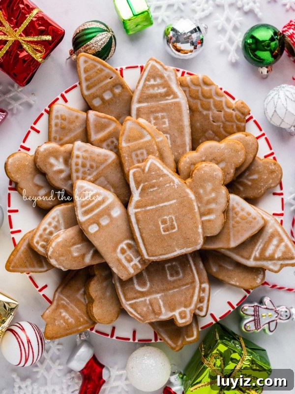 Chocolate Thumbprint Cookies with Raspberry Jam Filling 5 Christmas themed dessert plate filled with soft and chewy gingerbread cookies with ornaments around it on a white marbled background.