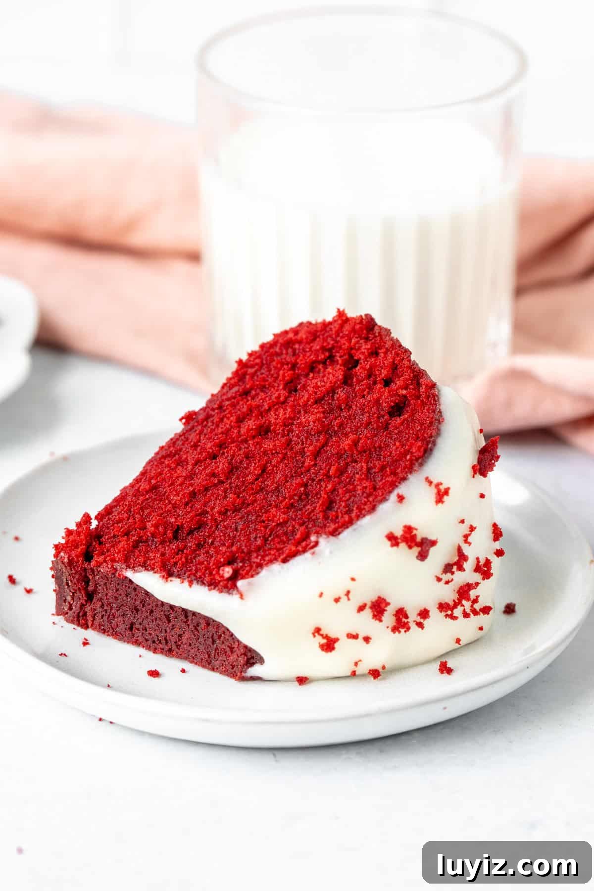 Moist Red Velvet Bundt Cake Recipe with Cream Cheese Glaze 3 Slice of red velvet cake on a plate with glass of milk