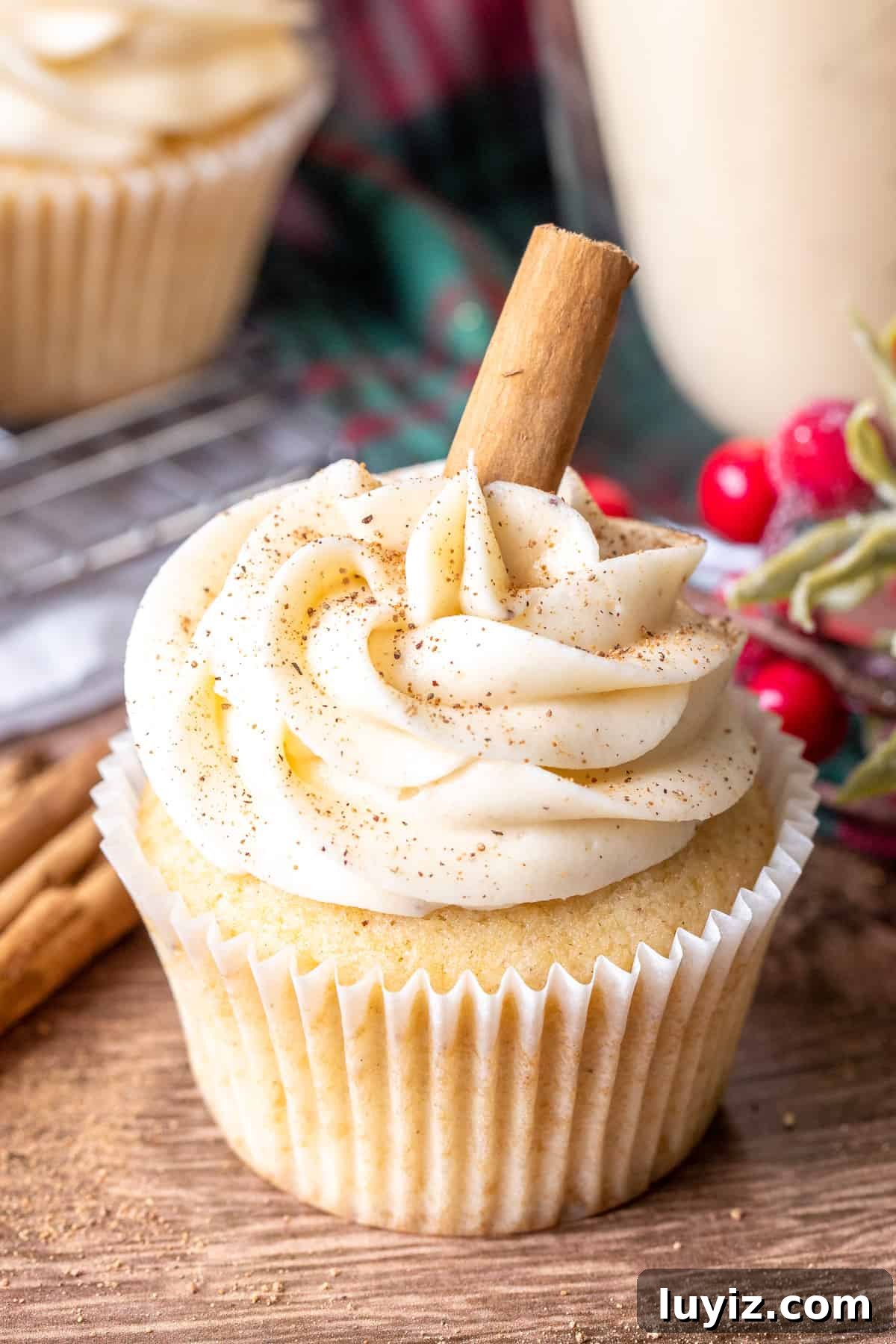 Eggnog cupcake topped with eggnog frosting and a cinnamon stick