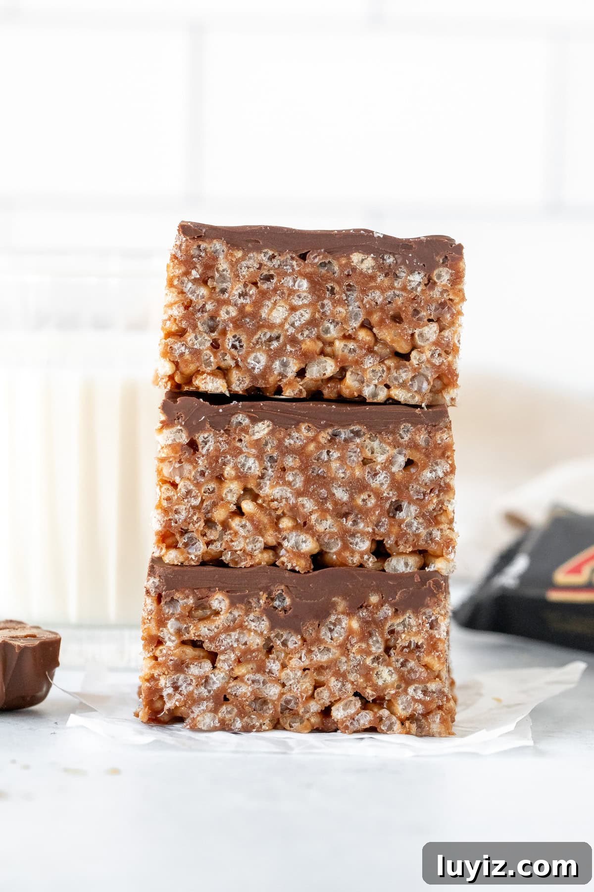 Chewy Mars Bar Squares Recipe with Chocolate Caramel Layer 2 Stack of three Mars bar squares with glass of milk