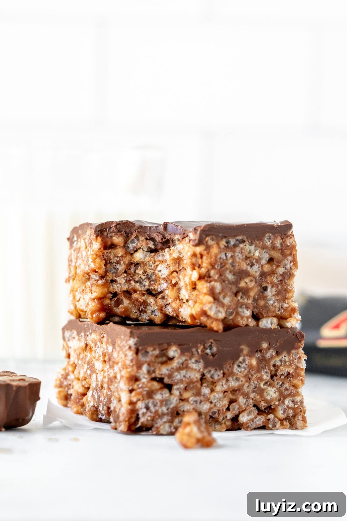 Chewy Mars Bar Squares Recipe with Chocolate Caramel Layer 6 Two Mars Bars squares, stacked on top of each other. Top square has a bite taken out