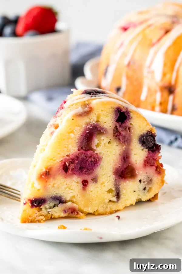 Moist Mixed Berry Bundt Cake Recipe with Lemon Glaze 3 Slice of berry pound cake on a plate.