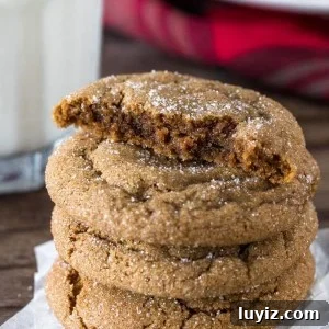 Soft Chewy Ginger Molasses Cookies Recipe 6 A stack of thick ginger molasses cookies with the top cookie broken in half.