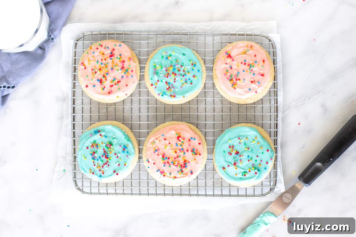 Soft-Batch Sour Cream Sugar Cookies — Ultra-Soft, Tender Cookies 3 6 frosted sugar cookies on a cooling rack