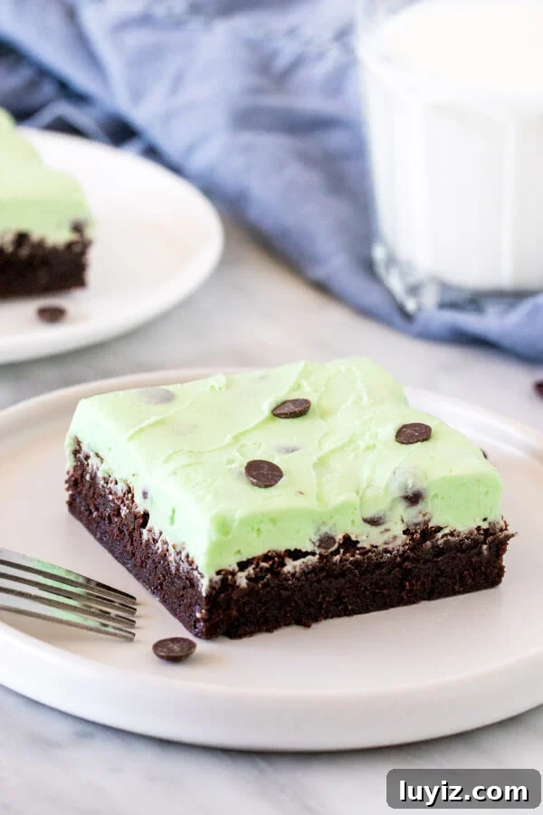 Mint-Chocolate Chip Brownies: Gooey Minty Chocolate Treat 2 Brownie topped with mint chip frosting on a plate with a glass of milk