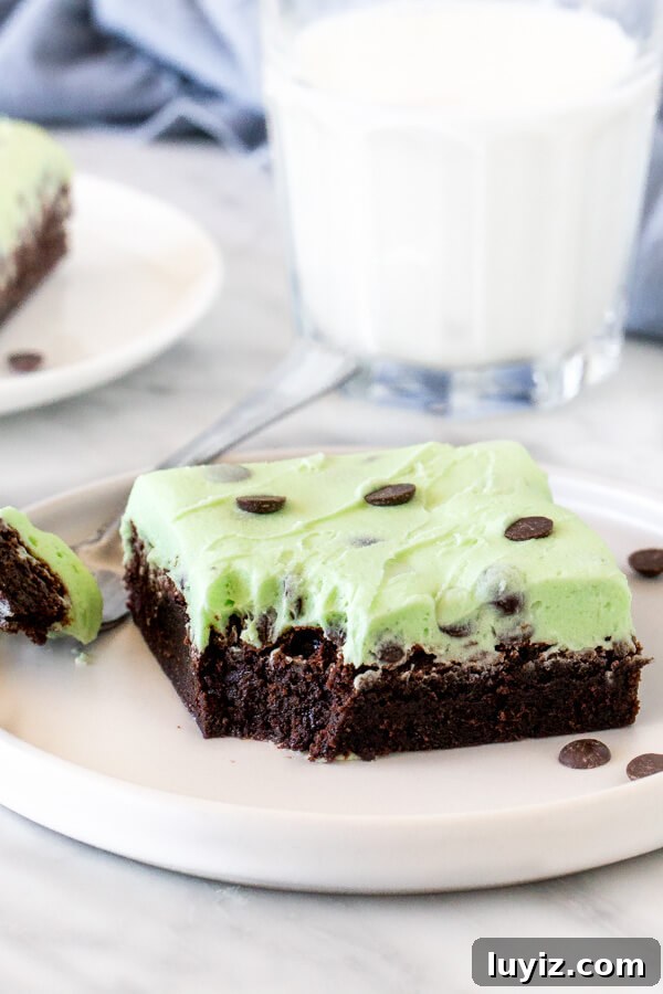Mint-Chocolate Chip Brownies: Gooey Minty Chocolate Treat 4 Mint chip brownie with a bite taken out of it on a plate with a fork.