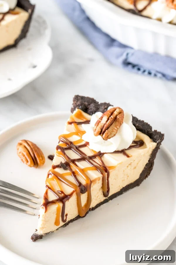Decadent Turtle Pie Recipe with Pecan-Caramel Crunch 2 Slice of turtle pie on a plate drizzled with caramel and chocolate sauce.