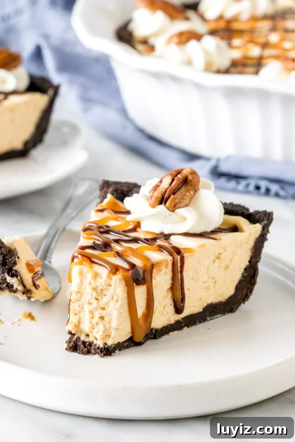 Decadent Turtle Pie Recipe with Pecan-Caramel Crunch 4 Piece of frozen turtle pie with a bite taken out of it on a plate.