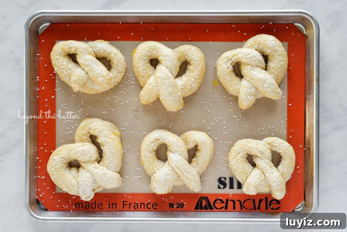 How to Make Soft Homemade Pretzels Step-by-Step 7 Pre-baked homemade soft pretzels on silicone lined baking sheet