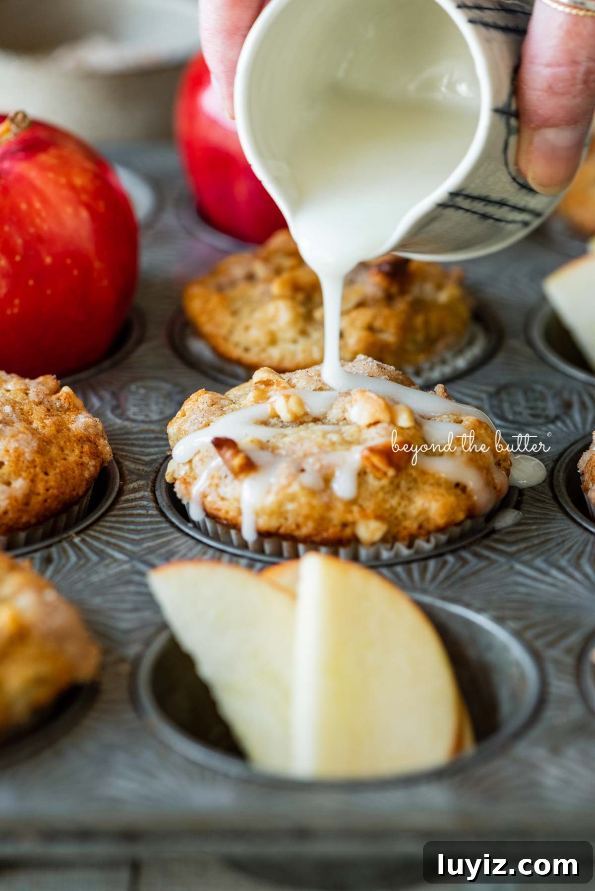 Apple Cinnamon Streusel Muffins Recipe with Crunchy Topping 3 Drizzling warm vanilla glaze over top of apple cinnamon streusel muffins