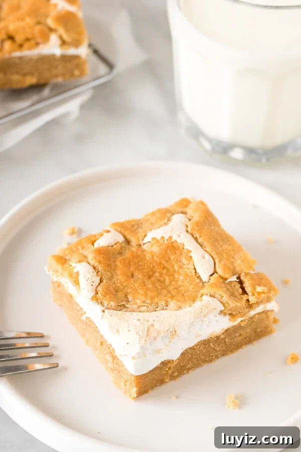 Fluffernutter Bars Recipe: Classic Peanut Butter & Marshmallow Squares 3 Fluffernutter bar on a plate with a glass of milk.