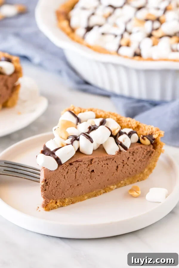 Decadent Rocky Road Pie Recipe: Chocolate, Marshmallows & Nuts 2 Slice of rocky road pie with marshmallows on top on a plate.