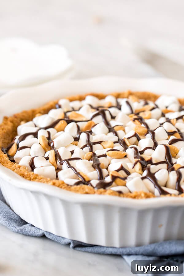 Decadent Rocky Road Pie Recipe: Chocolate, Marshmallows & Nuts 3 Rocky road cheesecake in a pie pan topped with marshmallows, peanuts and chocolate.