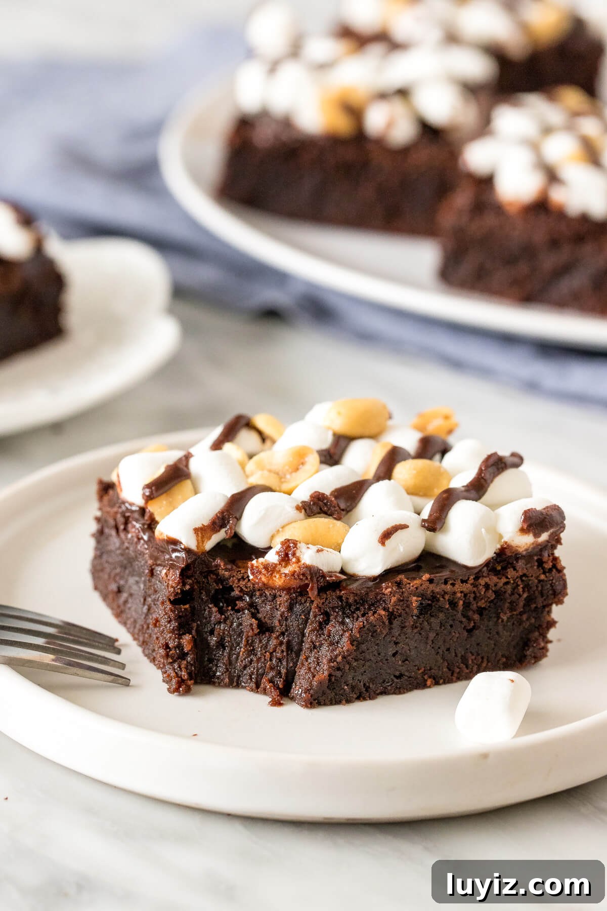 Decadent Rocky Road Brownies Recipe with Chocolate & Marshmallows 4 Rocky road brownie on a plate with a bite taken out of it.