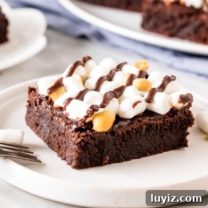 Decadent Rocky Road Brownies Recipe with Chocolate & Marshmallows 5 A rocky road brownie with marshmallows and peanuts on a plate.