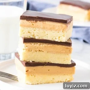 Peanut Butter Shortbread Bars Recipe — Buttery, Crunchy Treat 7 Stack of 3 peanut butter shortbread bars with a glass of milk.
