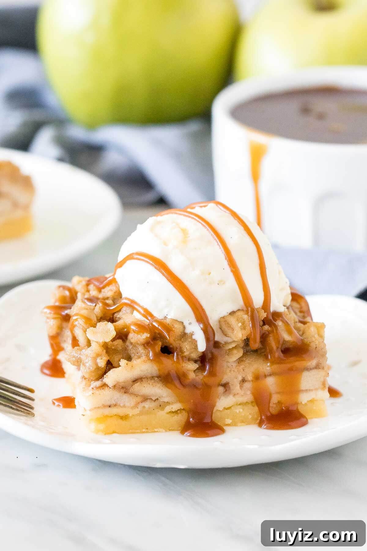 Chewy Apple Crisp Bars with Cinnamon Streusel 2 Apple crisp bar with a scoop of ice cream and caramel drizzle on top.