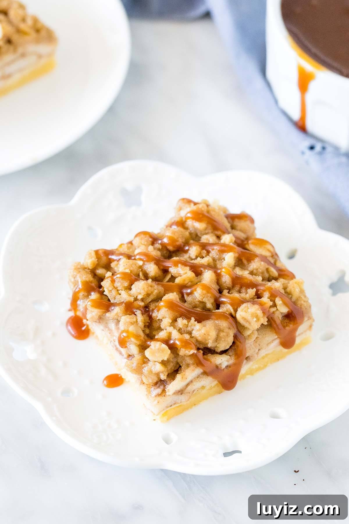 Chewy Apple Crisp Bars with Cinnamon Streusel 3 Slice of apple crumble on a plate with a drizzle of caramel on top.