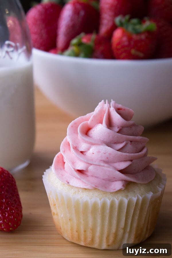 Vanilla Cupcakes with Strawberry Buttercream. Light, fluffy, super moist vanilla cupcakes topped with creamy strawberry buttercream.