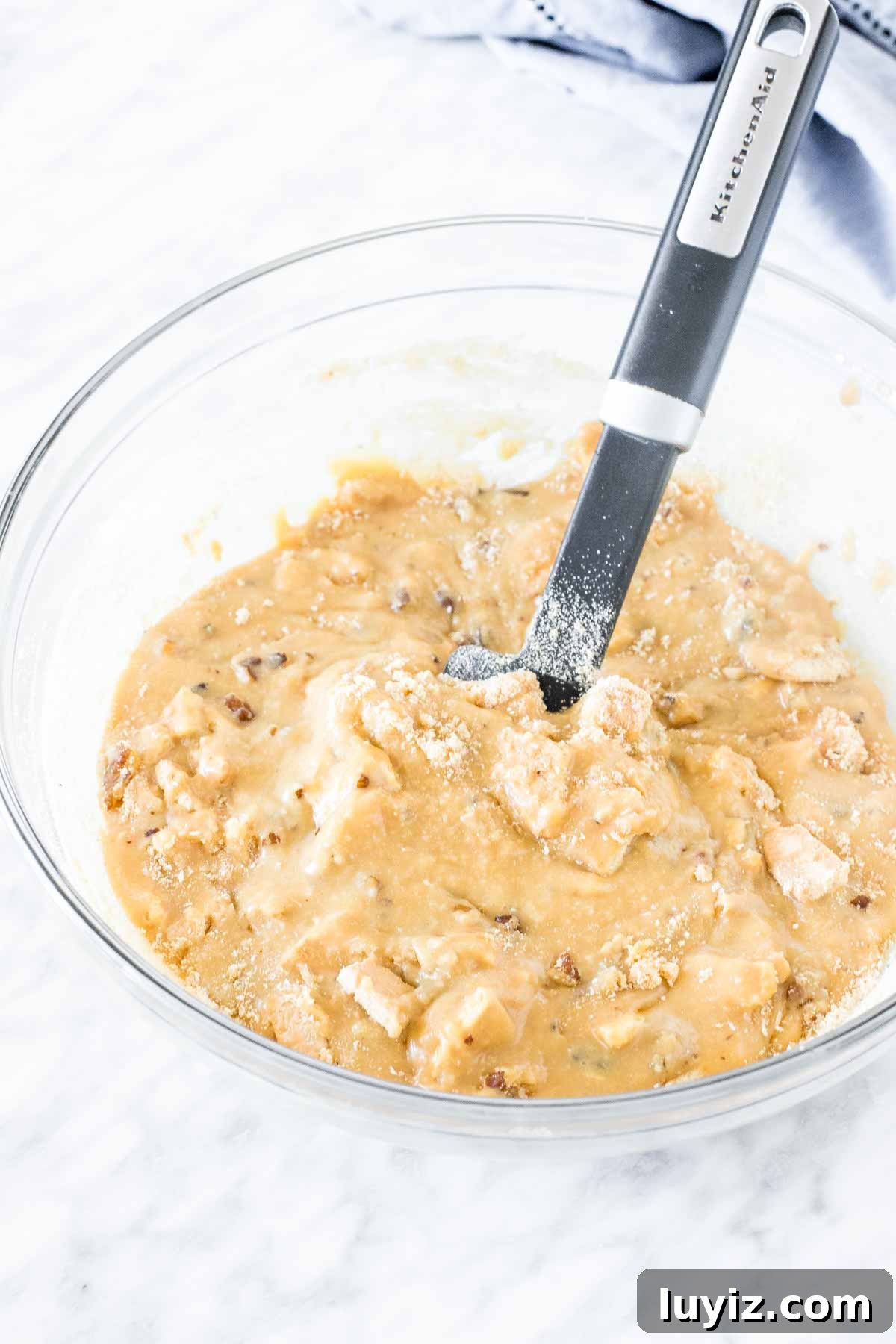 Caramilk Slice Recipe: Creamy No-Bake Caramel Chocolate Bars 3 Bowl of melted white chocolate with biscuits and nuts mixed in.