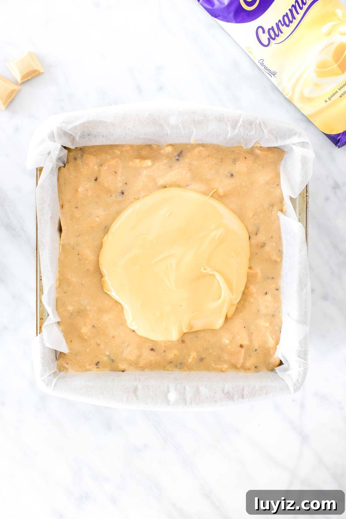 Caramilk Slice Recipe: Creamy No-Bake Caramel Chocolate Bars 4 Pan of Caramilk slice, with melted white chocolate poured on top.