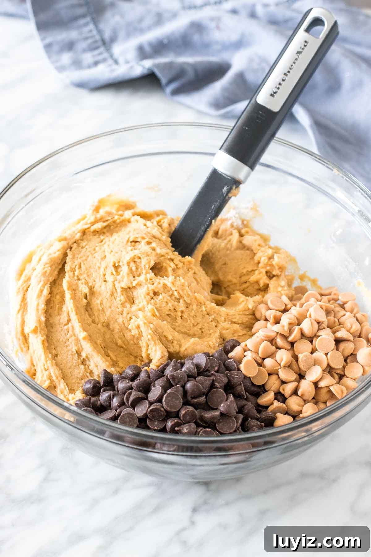 Chewy Peanut Butter Cookie Bars Recipe — Simple Crowd-Pleaser 4 Bowl of cookie dough with chocolate chips and peanut butter chips.