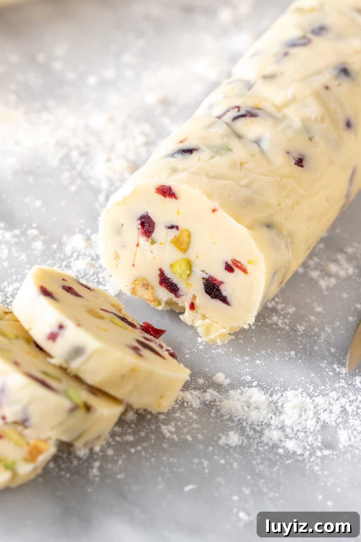 Cranberry Pistachio Shortbread Cookies Recipe 4 Log of unbaked shortbread cookie dough sliced into cookies.