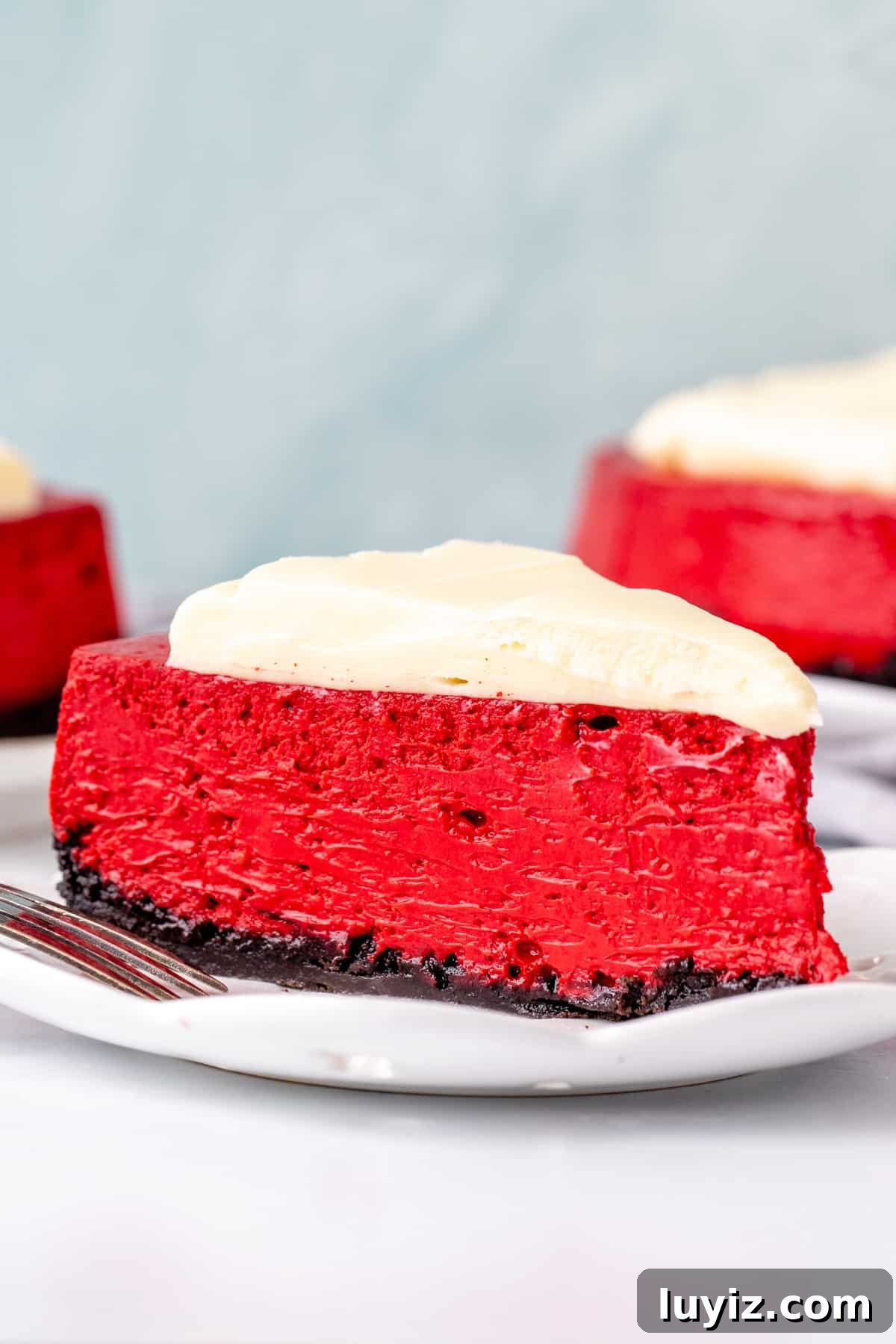 Decadent Red Velvet Cheesecake Recipe for Every Occasion 2 Slice of red velvet cheesecake with cream cheese topping