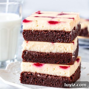 Stack of three raspberry cheesecake brownies on a plate.