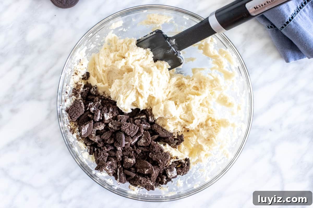 Oreo Cheesecake Stuffed Cookies: Decadent No-Bake Recipe 3 Bowl of cookie dough with chopped Oreo cookies.