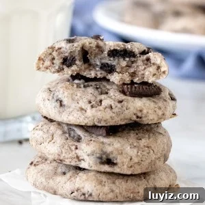 Stack of Oreo cheesecake cookies with the top cookie broken in half.