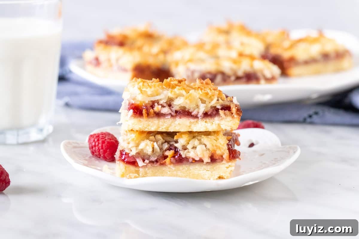Raspberry Coconut Bars Recipe: Chewy Fruit-Filled Dessert Bars 6 2 raspberry jam bars with coconut topping, stacked on a plate.