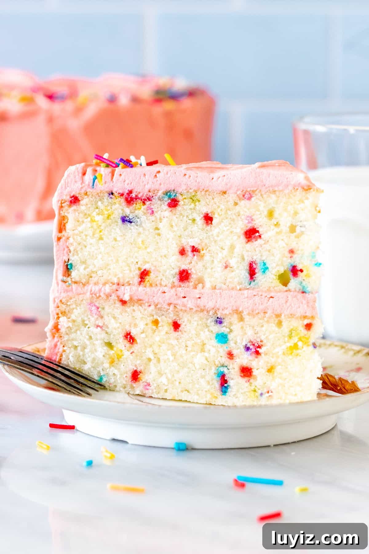 Scratch-Made Funfetti Cake Filled with Rainbow Sprinkles 2 Slice of funfetti cake with pink frosting