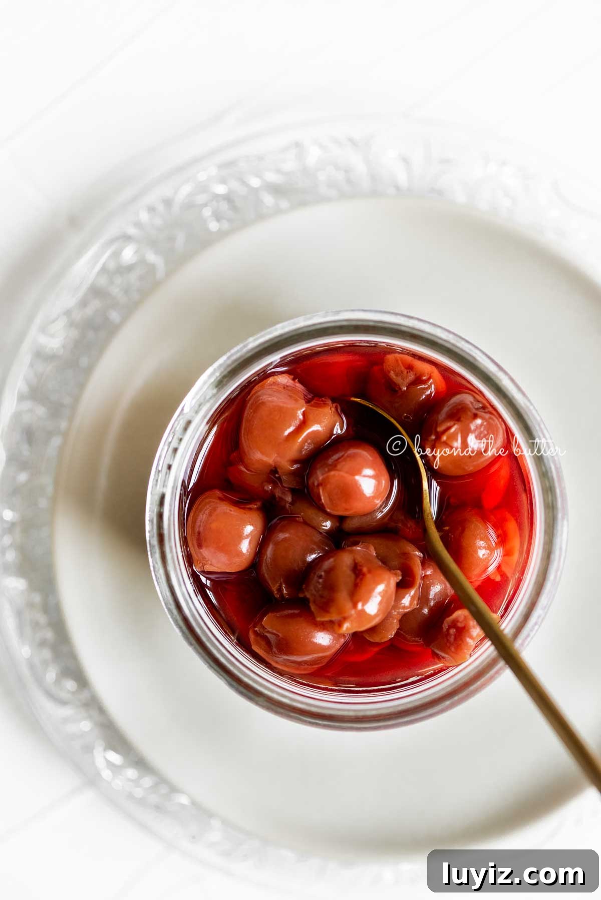 Classic Homemade Cherry Pie Recipe for Perfect Crust and Filling 4 Small glass jar of cherries with a spoon on top of 2 plates | All Images © Beyond the Butter™