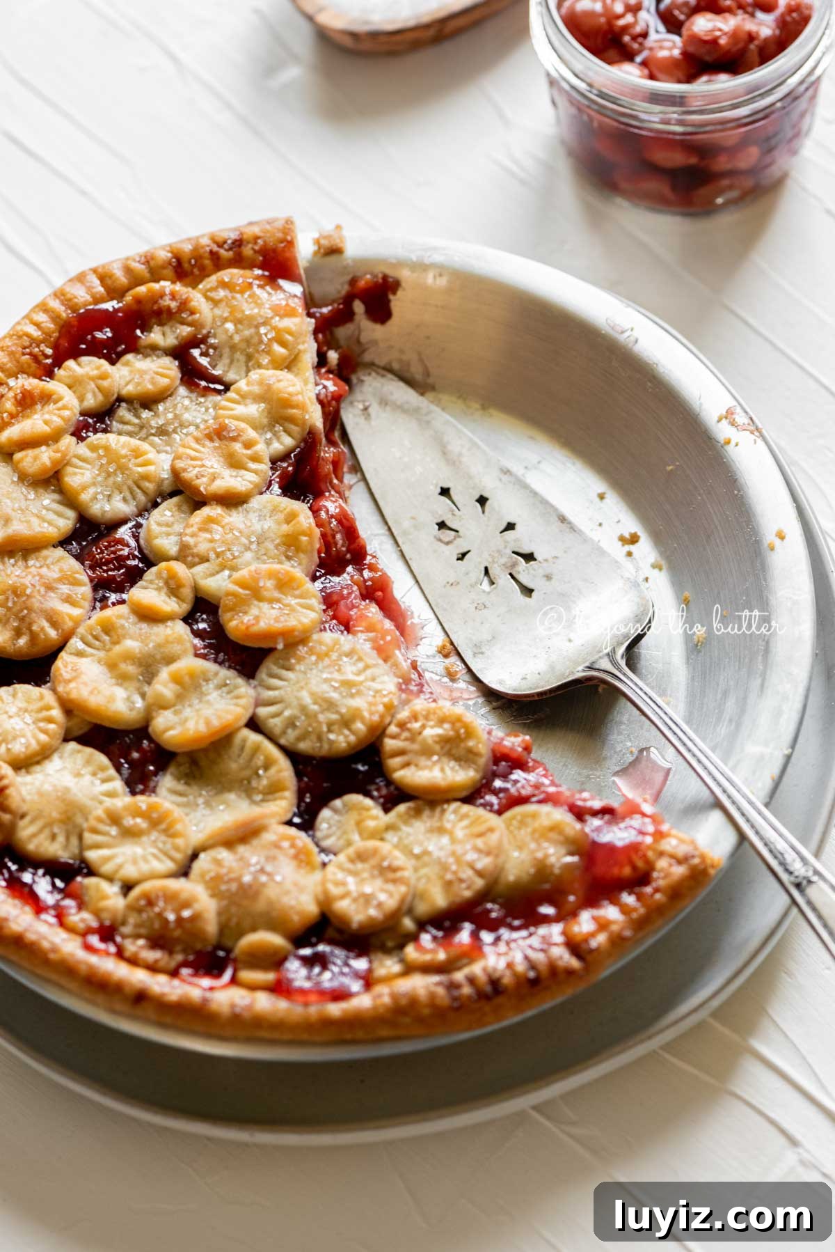 Classic Homemade Cherry Pie Recipe for Perfect Crust and Filling 6 Angled image of half eaten cherry pie with pie server placed on the pie plate | | All Images © Beyond the Butter™