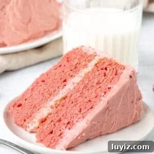 Moist Strawberry Layer Cake Recipe with Fresh Berry Frosting 11 Slice of strawberry cake with strawberry frosting with glass of milk