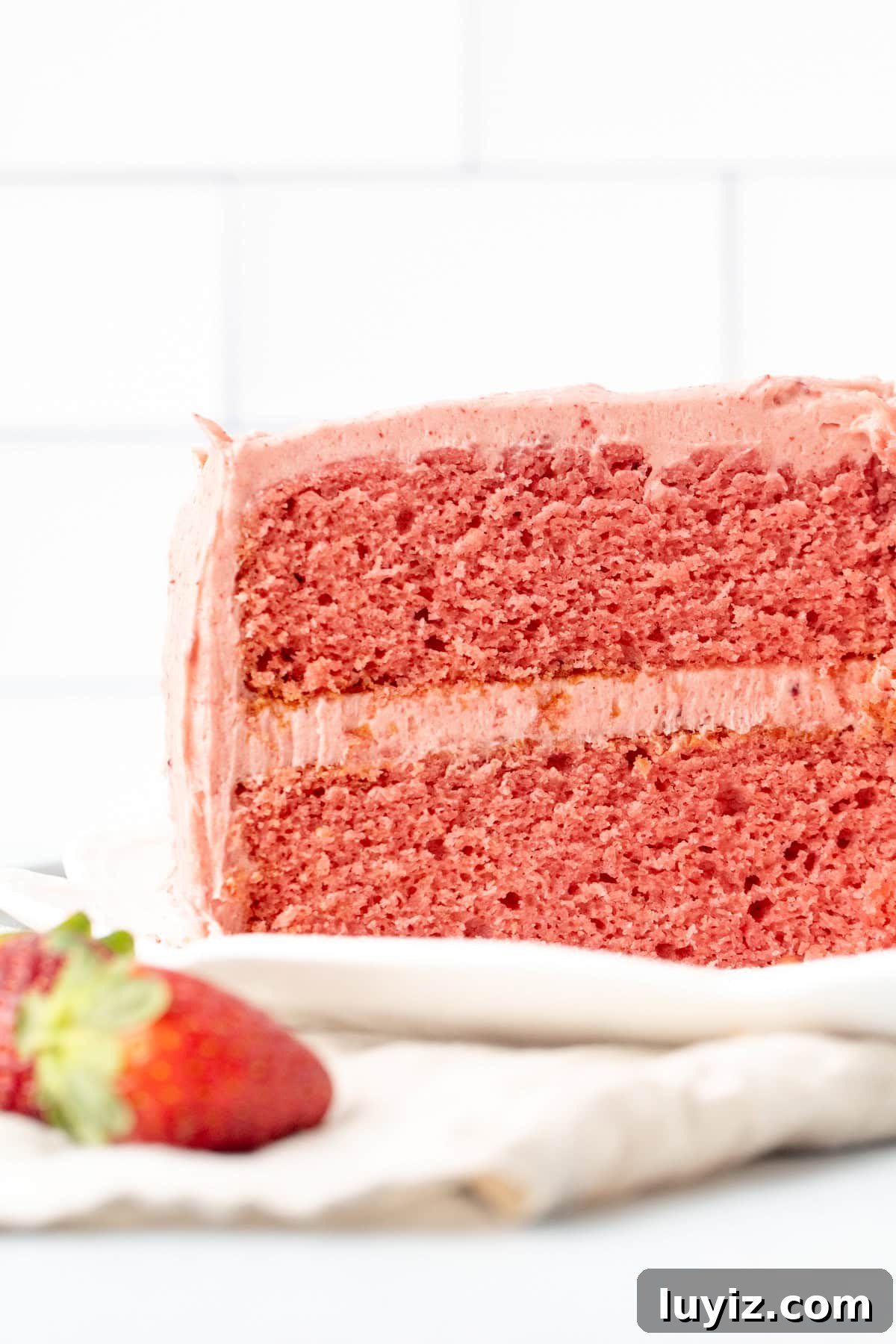 Moist Strawberry Layer Cake Recipe with Fresh Berry Frosting 3 2-layer strawberry cake with strawberry frosting with slices cut out of cake