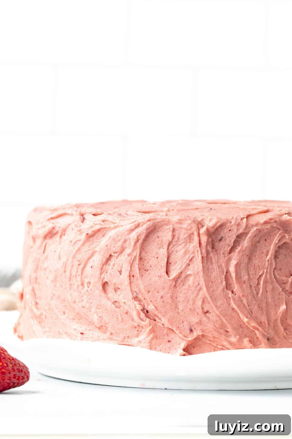 Moist Strawberry Layer Cake Recipe with Fresh Berry Frosting 9 8-inch round strawberry cake decorated with swirls of pink strawberry buttercream