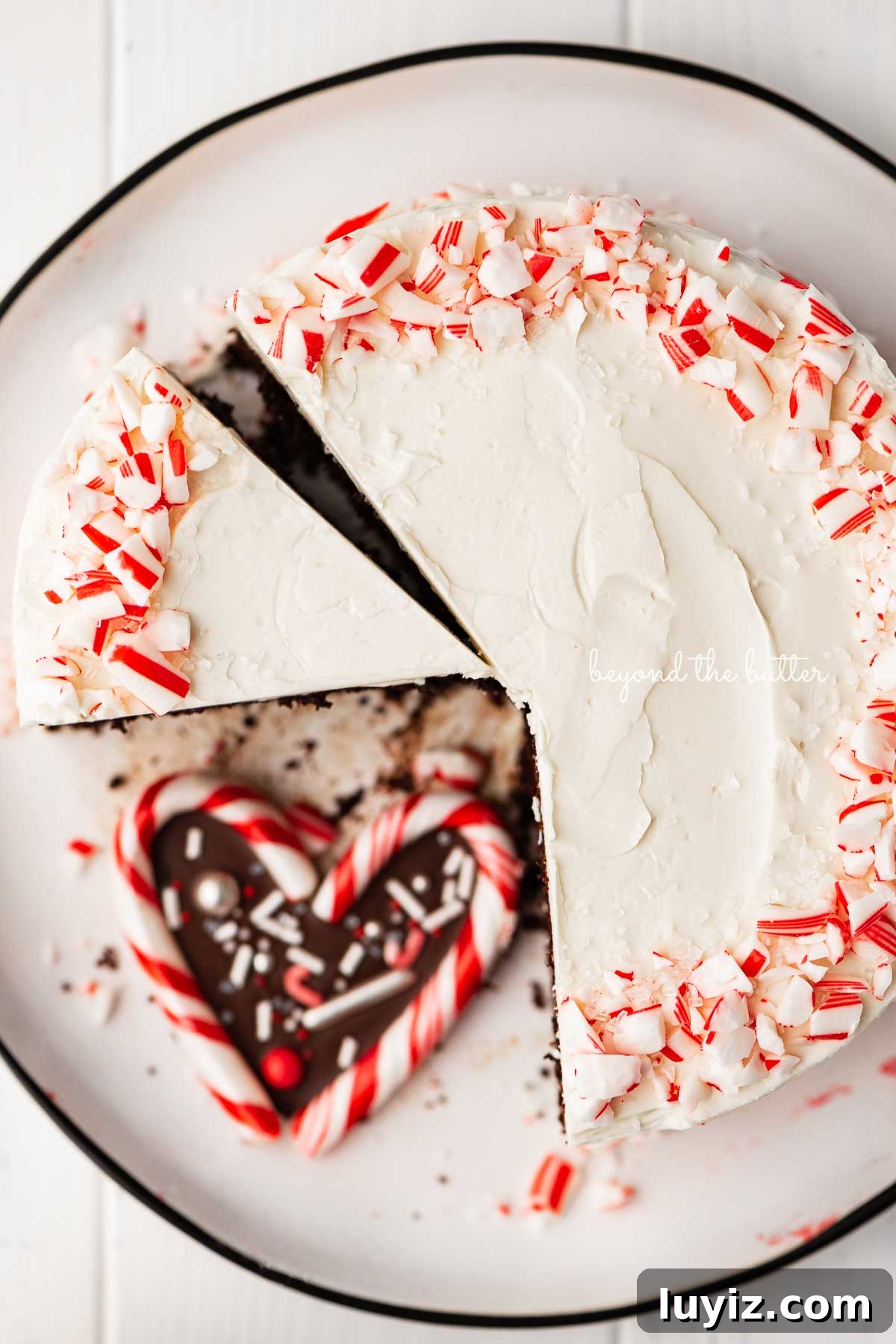 Peppermint Chocolate Cake Recipe: Single-Layer Holiday Dessert 4 Single layer chocolate peppermint cake sliced with candy cane heart placed on the dessert plate | © Beyond the Butter®