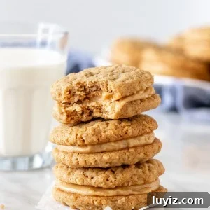 Stack of peanut butter sandwich cookies with glass of milk.