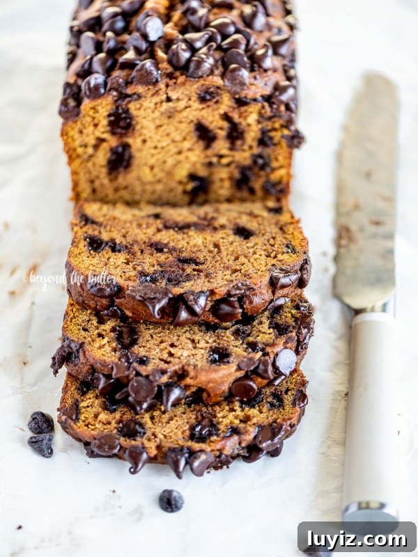 Perfect Pumpkin Pie Recipe for Creamy, Flaky Crust 11 Sliced chocolate chip pumpkin bread with knife and sprinkled chocolate chips on parchment paper lined table.