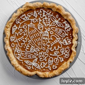 Perfect Pumpkin Pie Recipe for Creamy, Flaky Crust 13 Pumpkin Pie decorated with cream cheese frosting on white textured background.