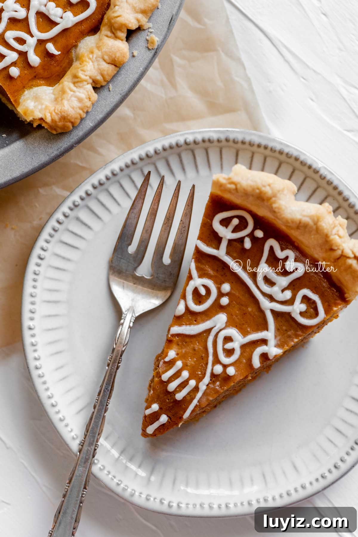 Perfect Pumpkin Pie Recipe for Creamy, Flaky Crust 3 Slice of pumpkin pie on a dessert plate with a fork resting on the plate and pie plate off to the side