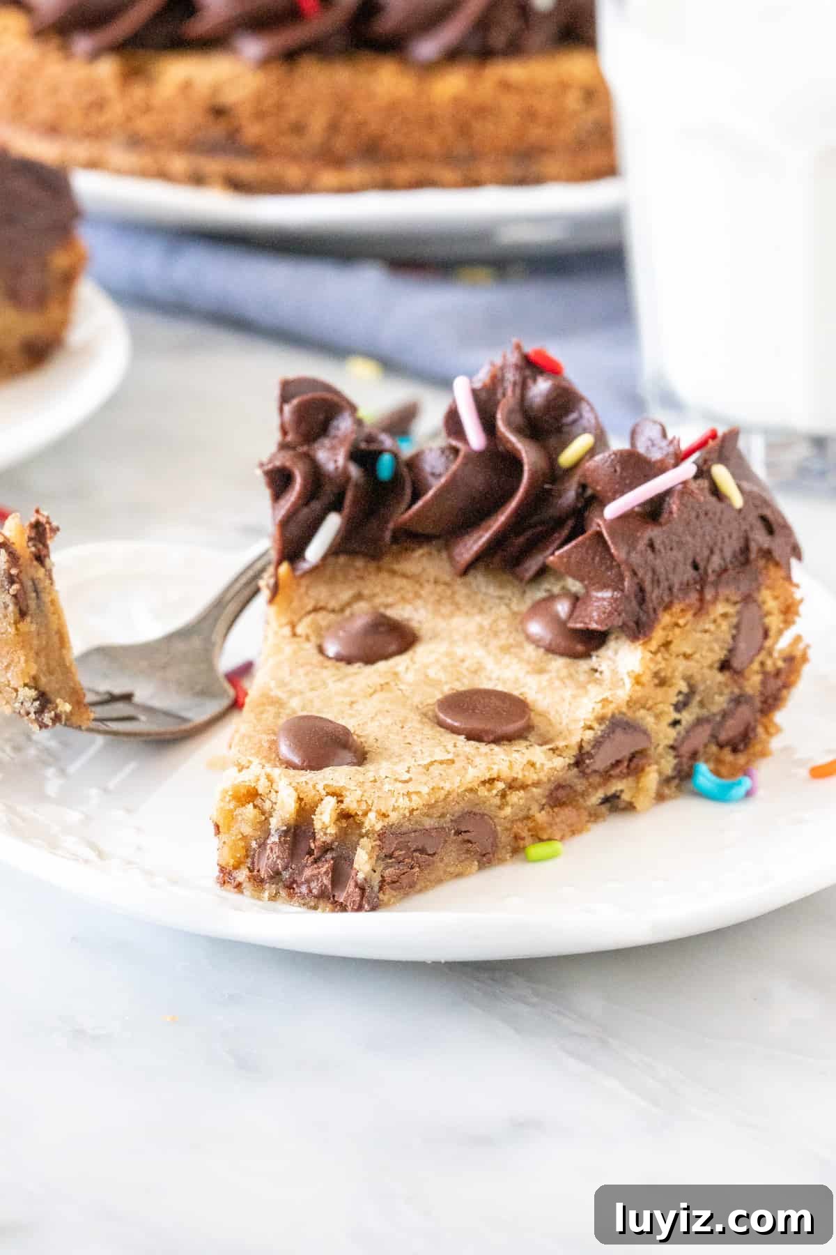 Ultimate Chocolate Chip Cookie Cake Recipe for Parties 5 Slice of chocolate chip cookie cake with a bite taken out.