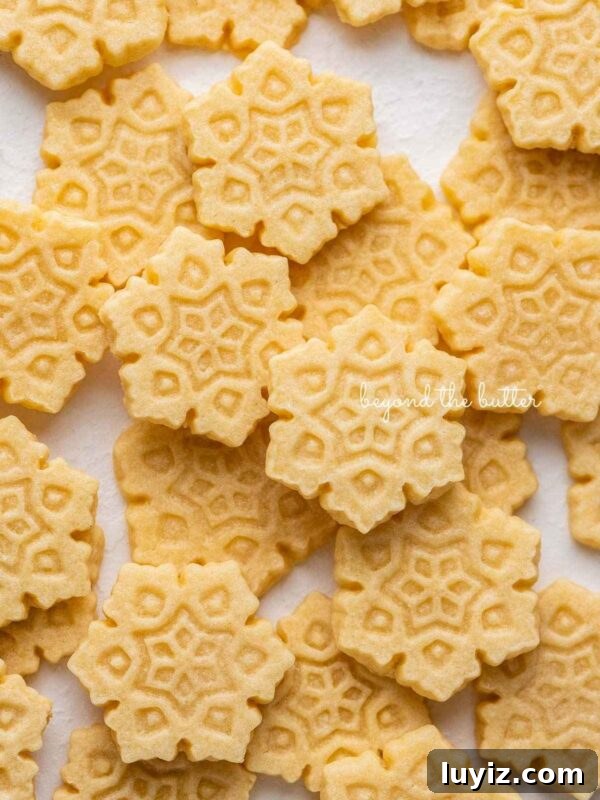 Classic Snickerdoodle Cookie Recipe: Soft Cinnamon Sugar Cookies 11 Butter cookies shaped as snowflakes on parchment.