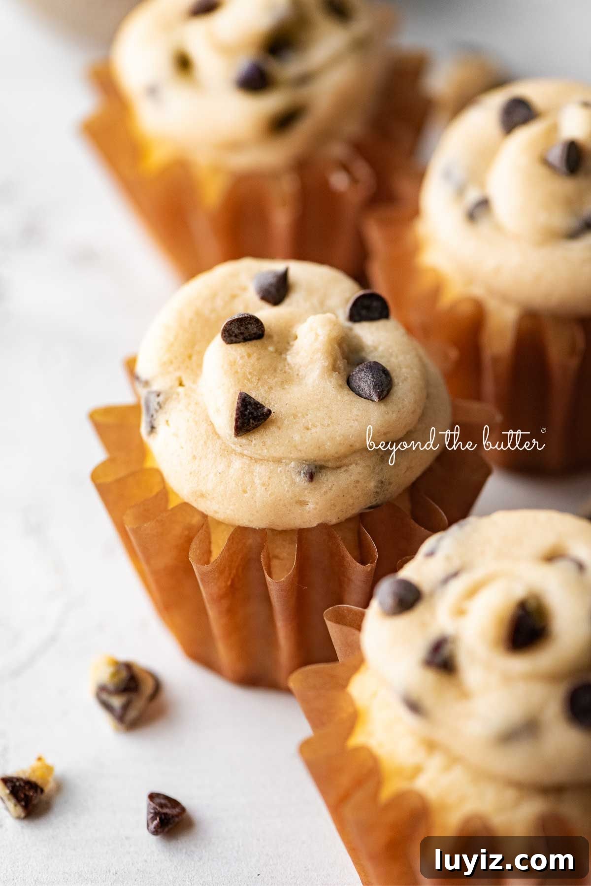 Chocolate Chip Cookie Dough Cupcakes Recipe with Gooey Centers 2 Small batch chocolate chip cookie dough cupcakes on a white marbled background.