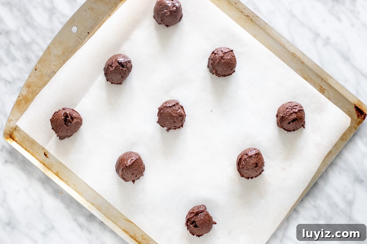 Chewy Brownie Cookies Recipe: Fudgy, Crispy-Edged Treats 6 Tray of chocolate cookie dough balls.
