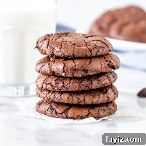 Chewy Brownie Cookies Recipe: Fudgy, Crispy-Edged Treats 9 5 brownie cookies stacked on top of each other.